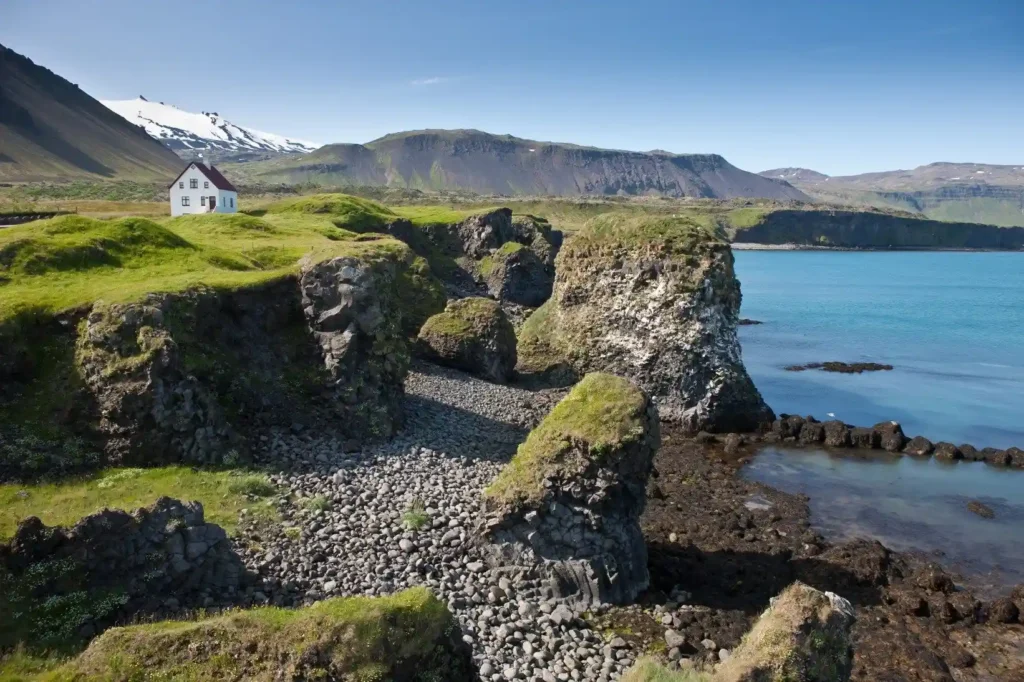 a house on a rocky cliff by the water